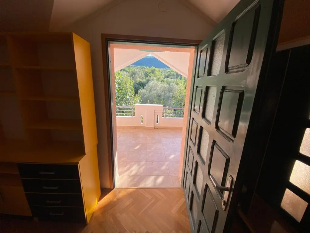 Open door to tiled terrace with hillside view