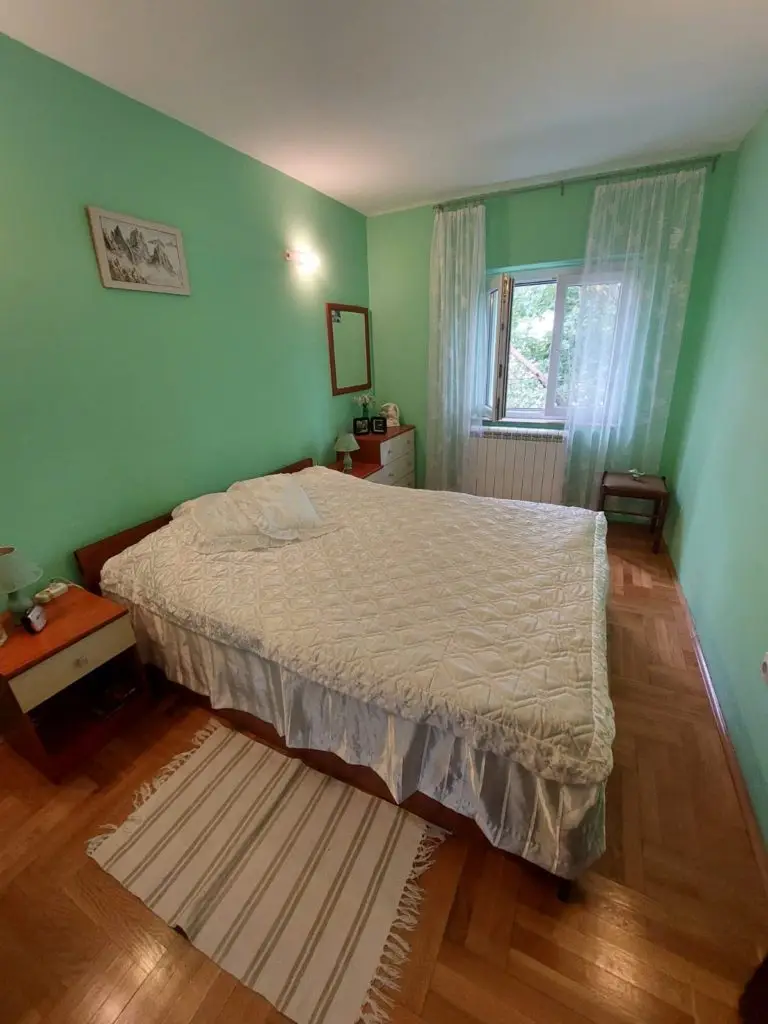 Green-walled bedroom with double bed and window