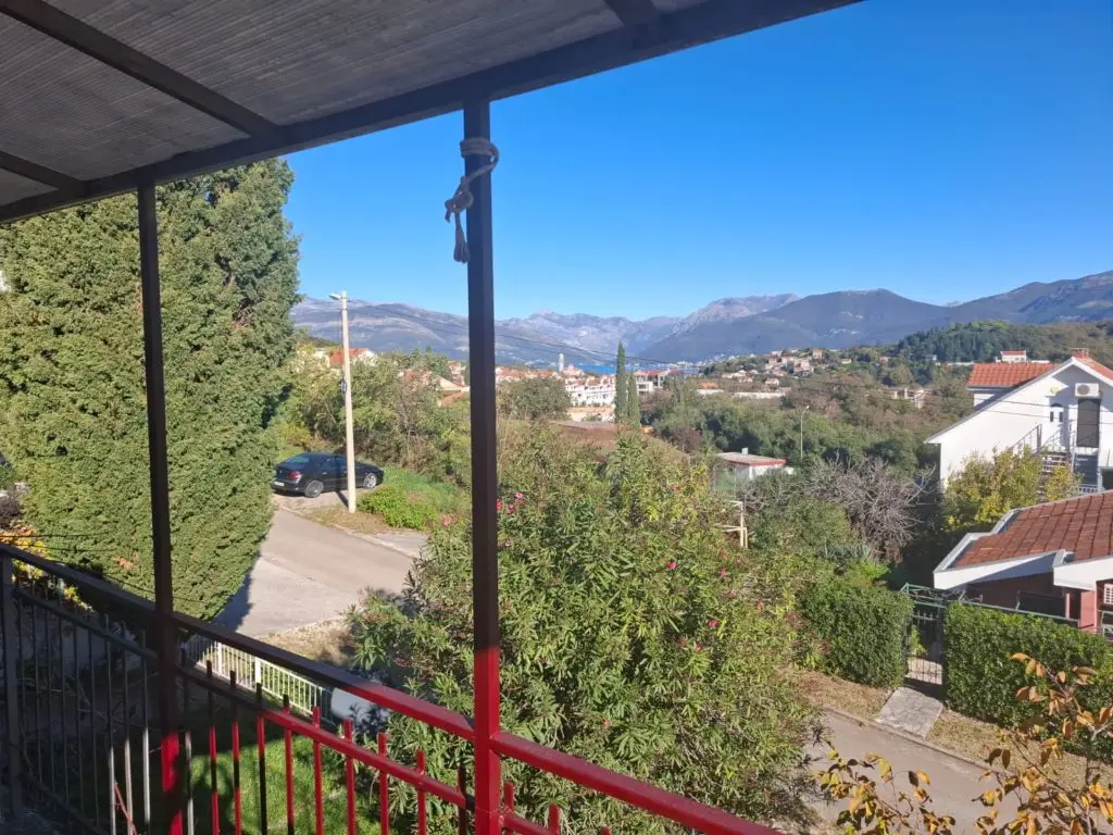 View from balcony over houses, trees, and mountains