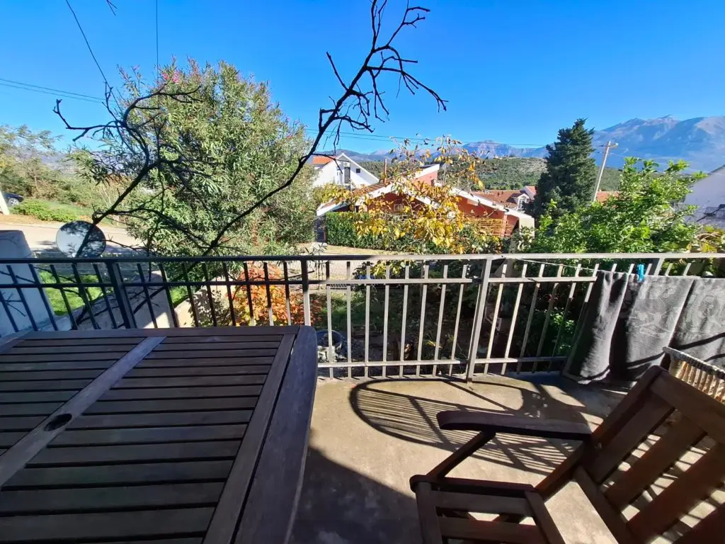 Balcony with table, chair, railing, and mountain view