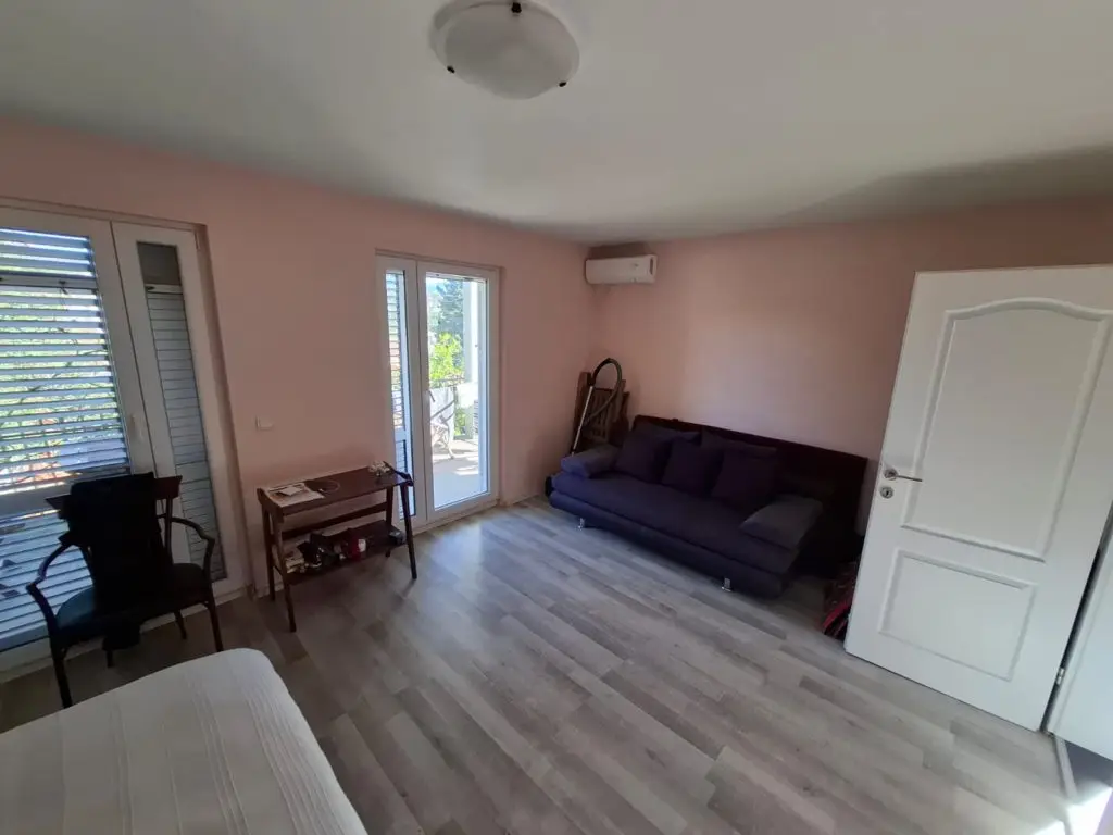 Pink-walled room with sofa, table, and open door