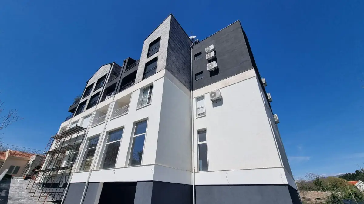 Modern white and dark gray apartment building with scaffolding