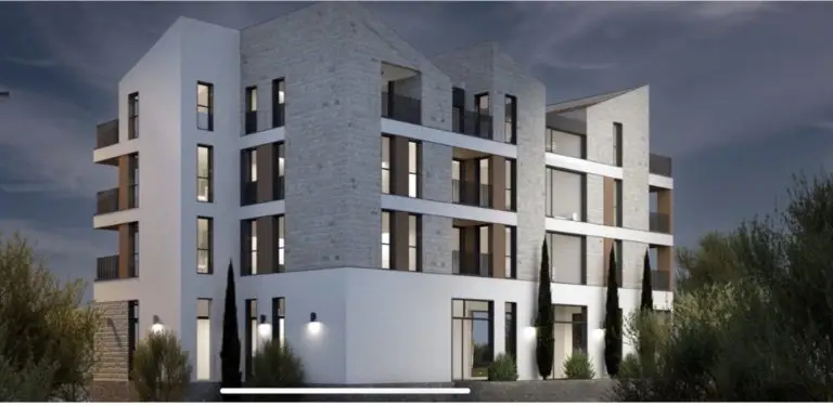 Modern four-story apartment building exterior at dusk
