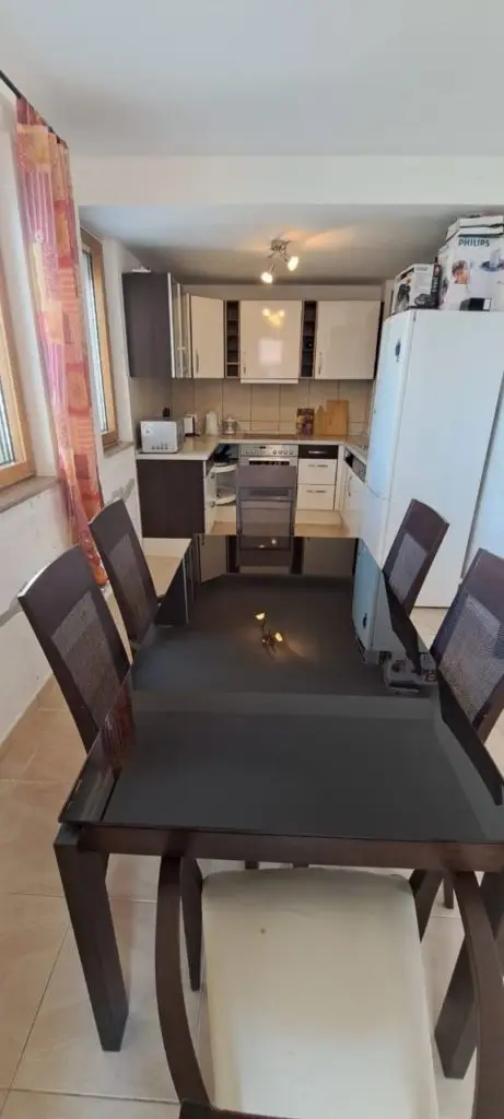 Dining table and chairs in a small kitchen with white cabinets