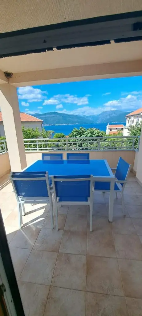 Covered terrace with blue dining set and sea view