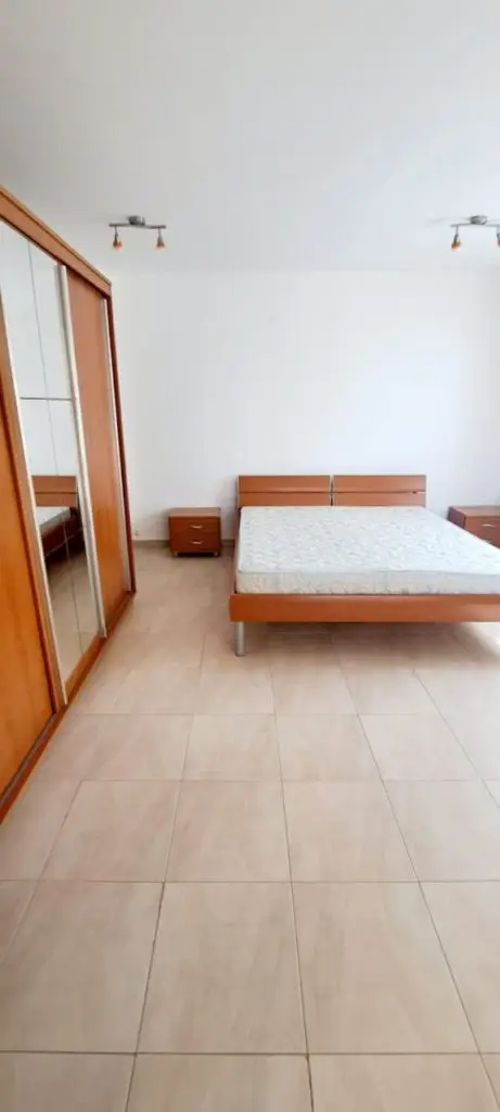 Minimalist bedroom with wooden bed, wardrobe, and nightstands