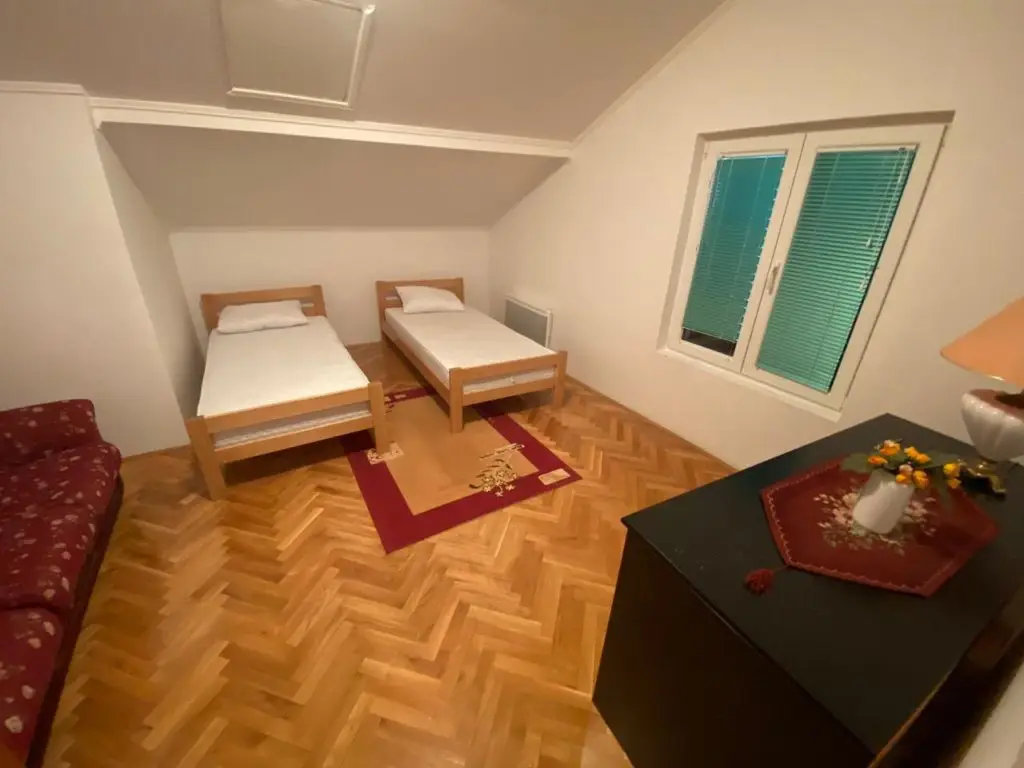 Small bedroom with two single beds and a window