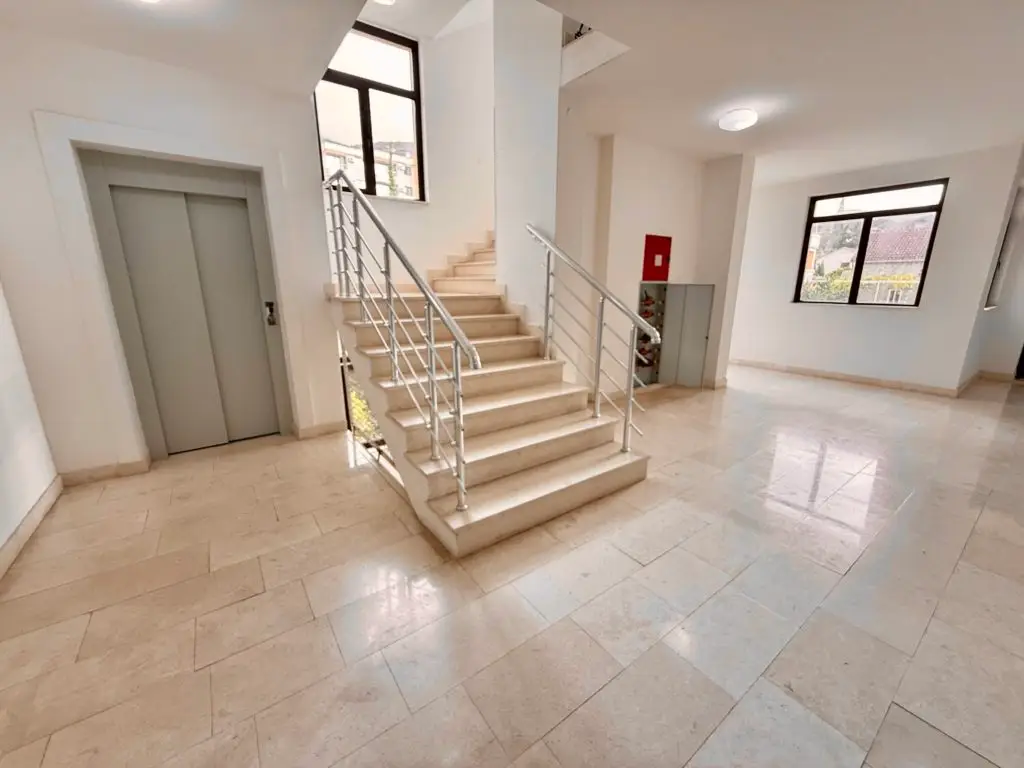 Apartment building lobby with staircase and elevator doors