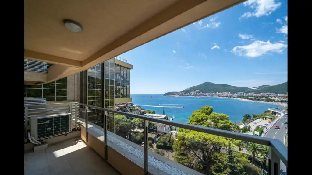 Balcony overlooking a bay and coastal town, with air conditioner