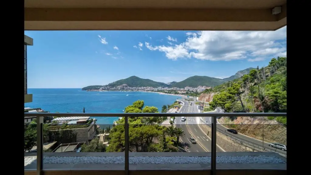 Balcony overlooking blue bay, road, and hills