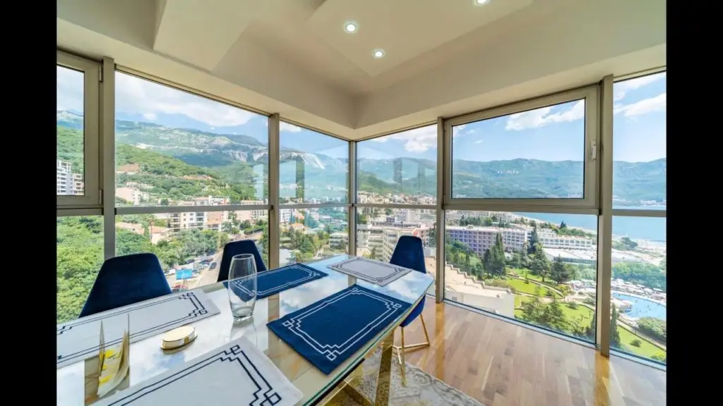 Dining table by floor-to-ceiling windows with mountain and sea view