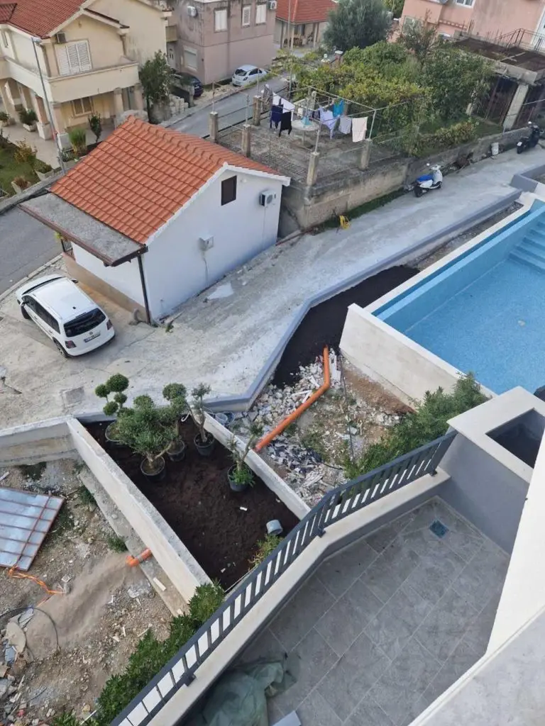 High-angle view of house, courtyard, and blue pool