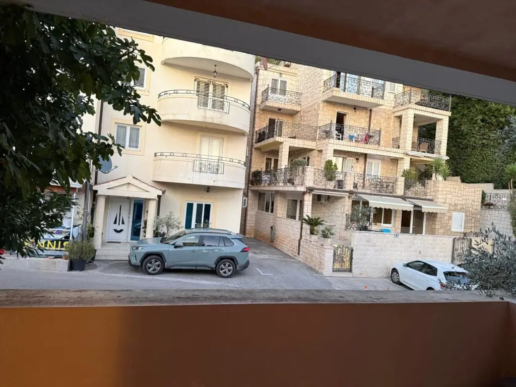 Apartment buildings with parked cars viewed through a window