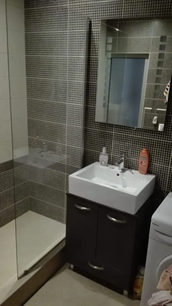 Bathroom with glass shower, sink vanity, and mirror