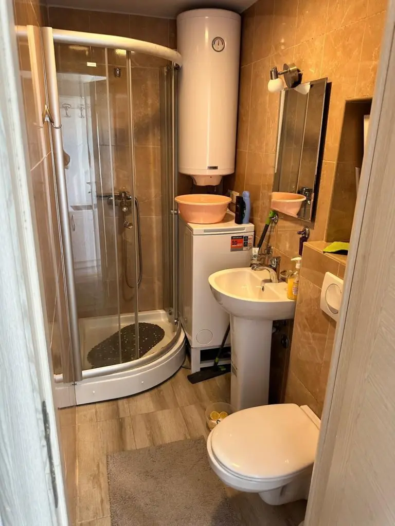 Small bathroom with shower, sink, toilet, and water heater