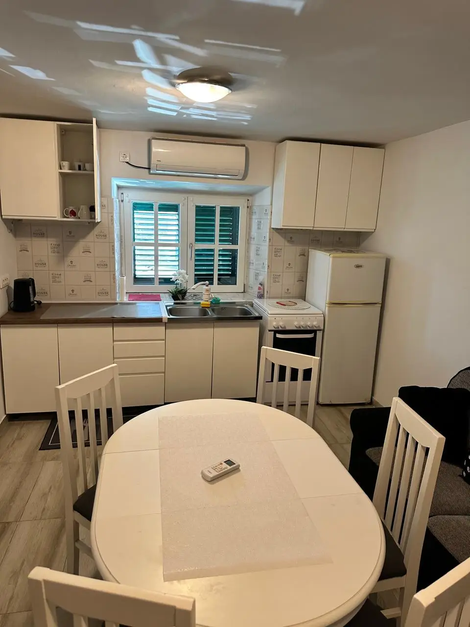 Compact kitchen and dining area with white cabinets
