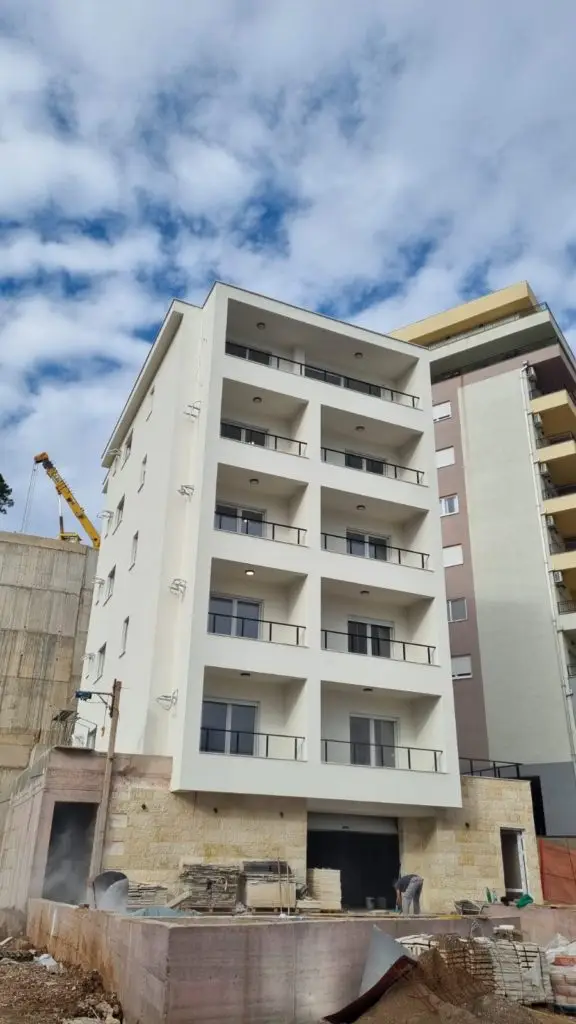 Partially finished apartment building with balconies and construction materials
