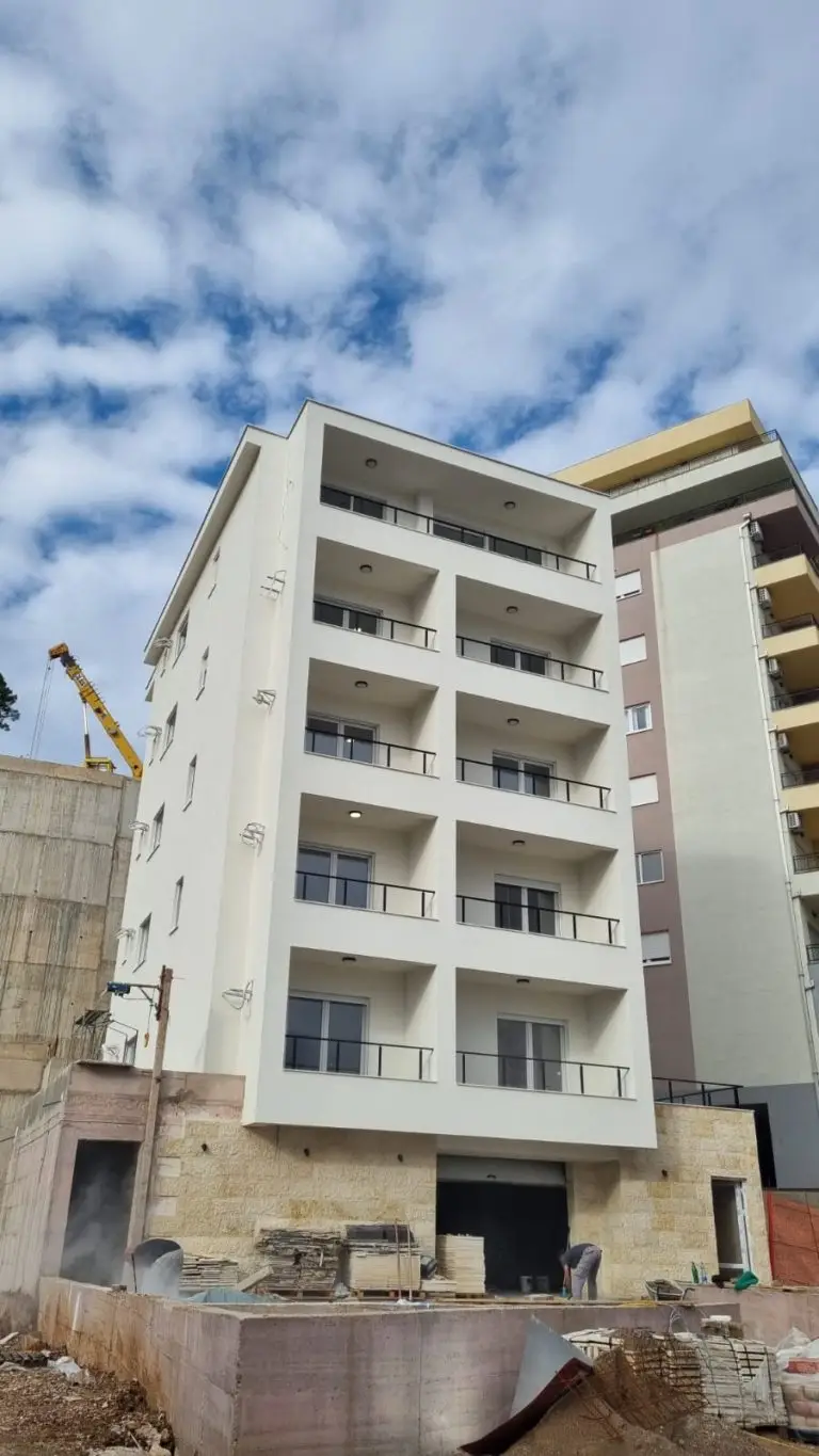 Partially finished apartment building with balconies and construction materials