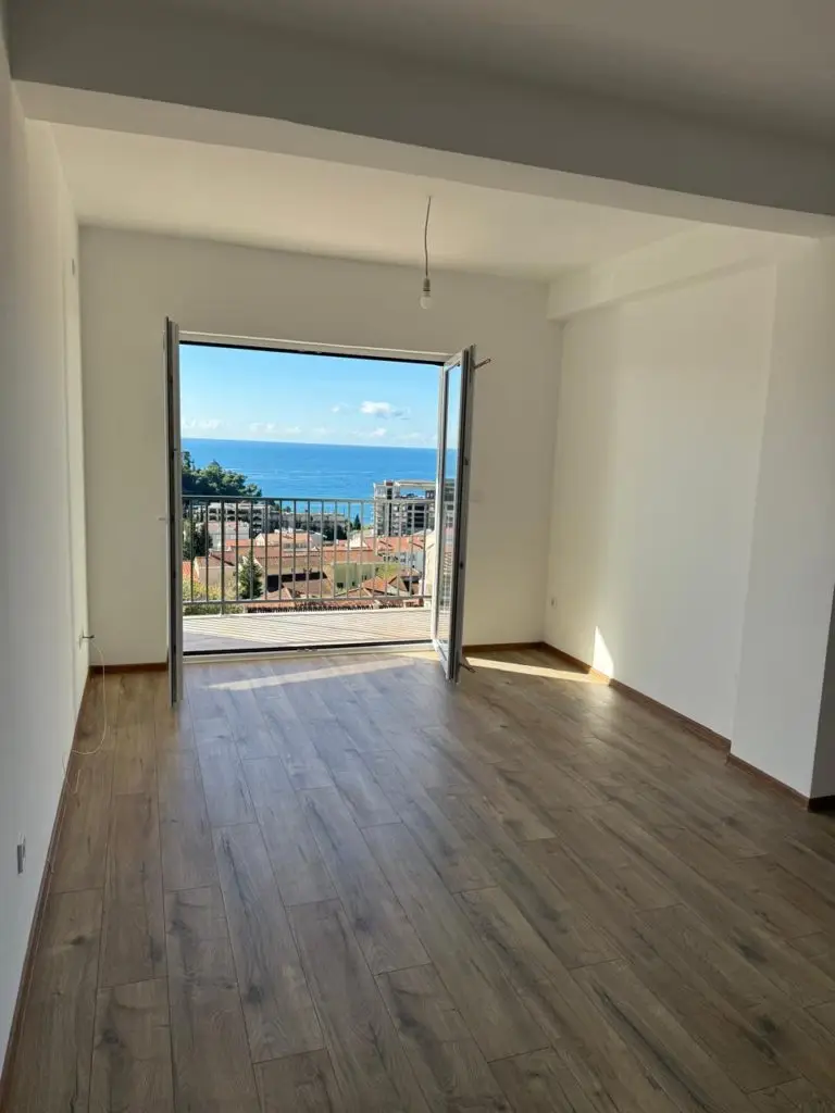 Empty room with open balcony doors and sea view
