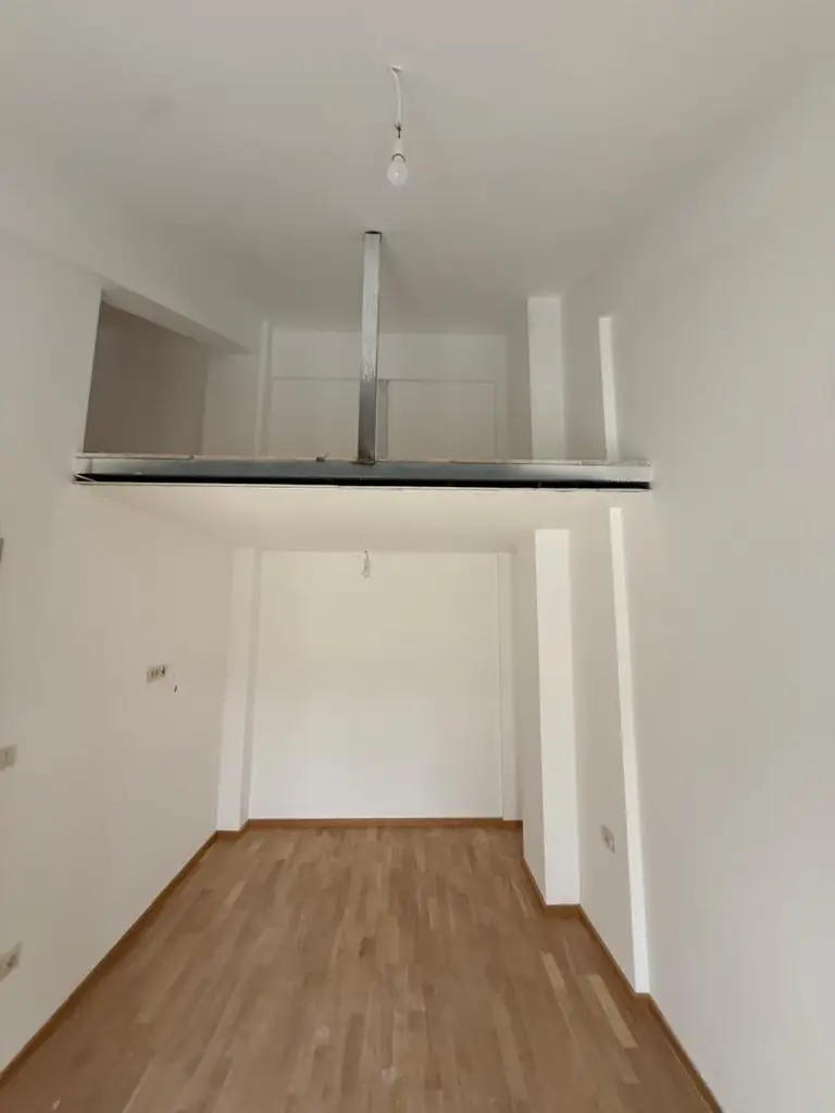 Empty white room with wood floor and mezzanine platform