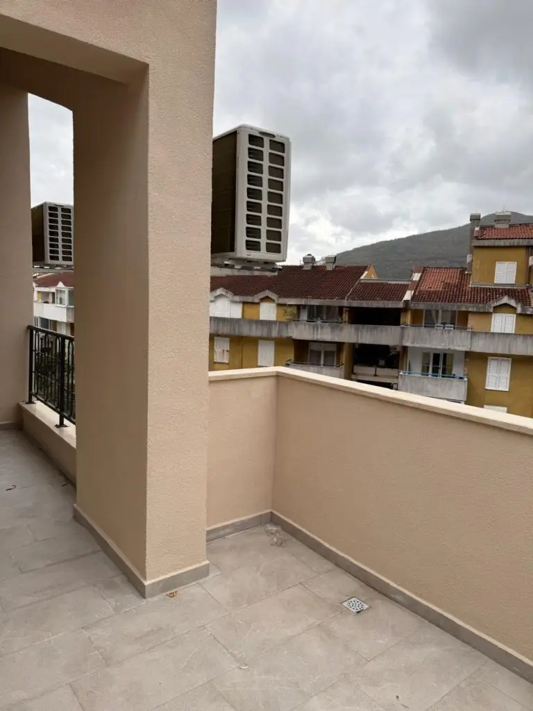 Beige terrace with air-conditioning units and apartment buildings beyond