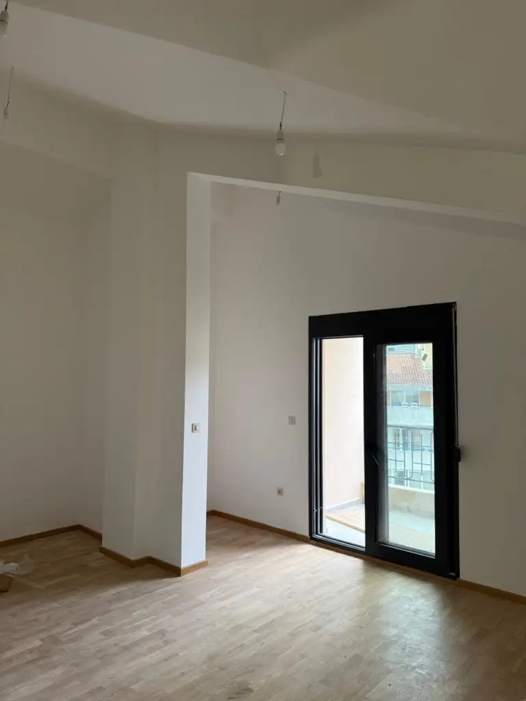 Empty room with wood floor and black balcony door