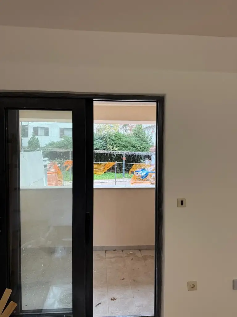 Black sliding glass door opening to a small balcony