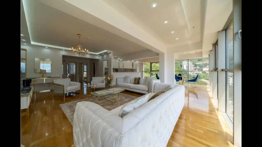 Modern living room with white sofas and large windows