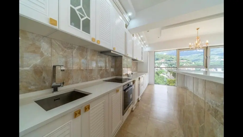 Bright white kitchen with marble backsplash and mountain view