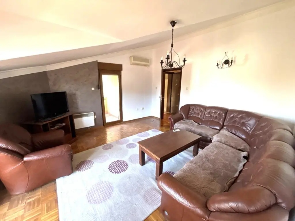 Living room with brown leather sectional and armchair