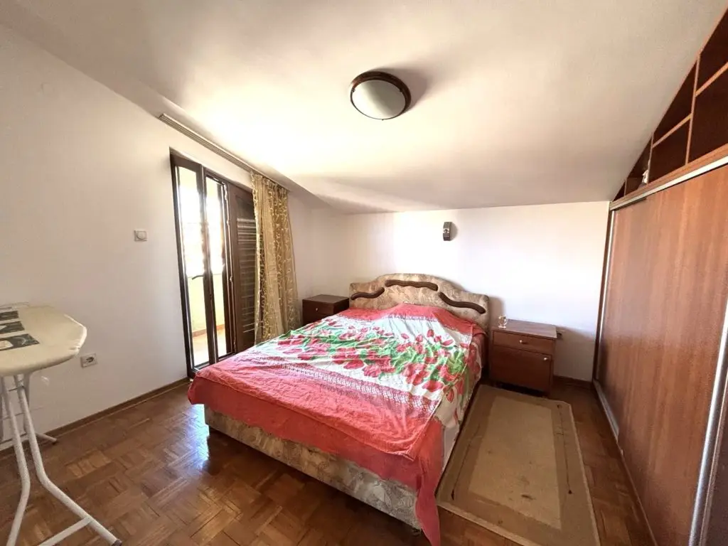 Bedroom with double bed, floral bedspread, and wardrobe