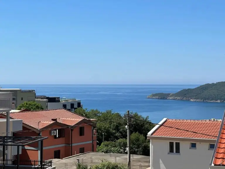 Rooftops overlooking the sea and a green peninsula