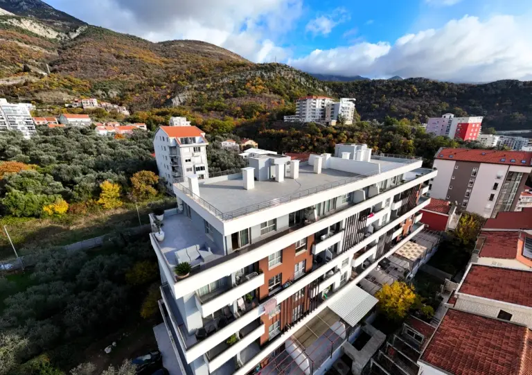 Aerial view of modern apartment building with rooftop terrace