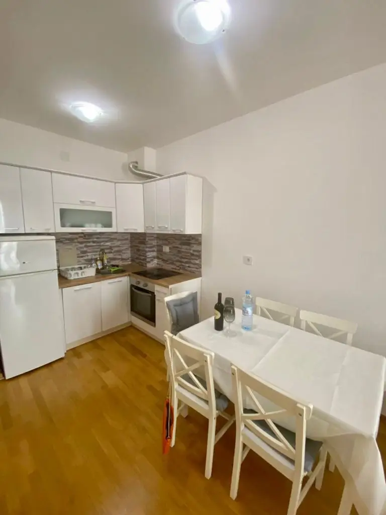 Small white kitchen and dining table with four chairs