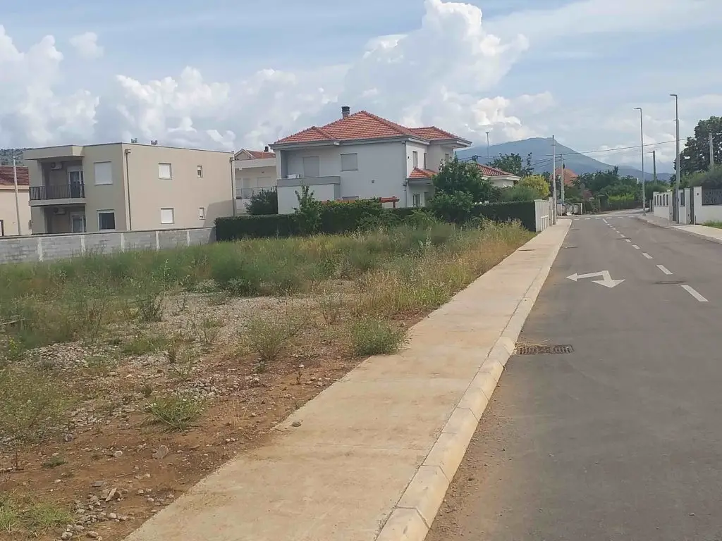 Residential street beside a vacant lot and houses