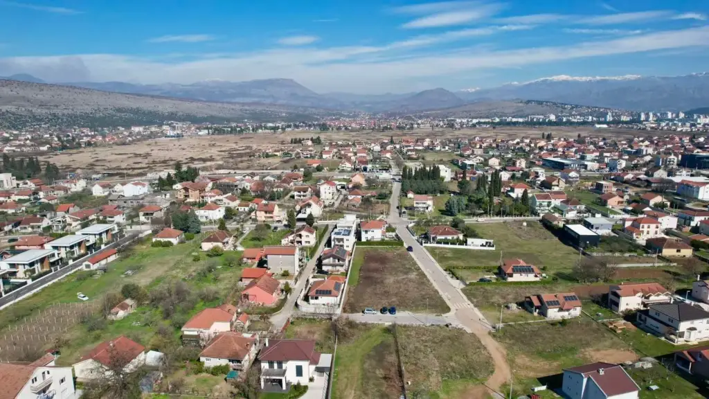 Aerial view of suburban housing plots and homes with mountains beyond