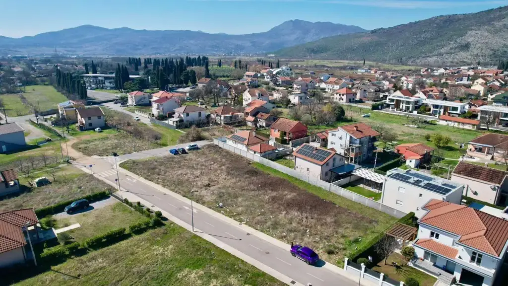 Aerial view of vacant lot in residential neighborhood with mountains