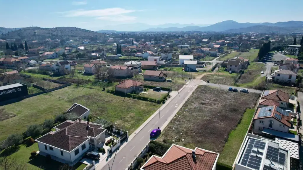 Aerial view of suburban neighborhood with vacant lots and houses