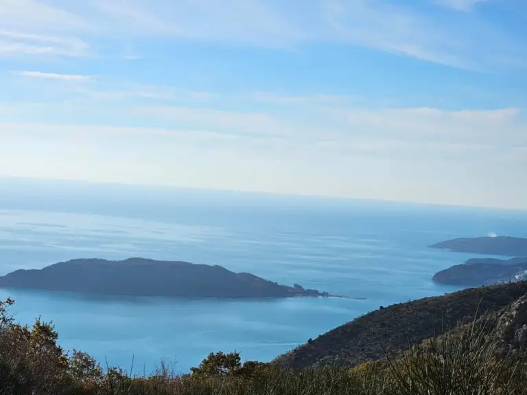Blue sea with islands and hills under cloudy sky