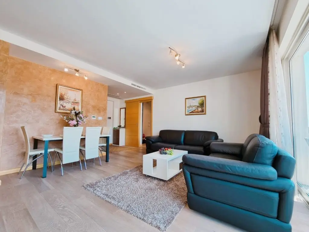 Modern living room with black sofas, dining table, and coffee table