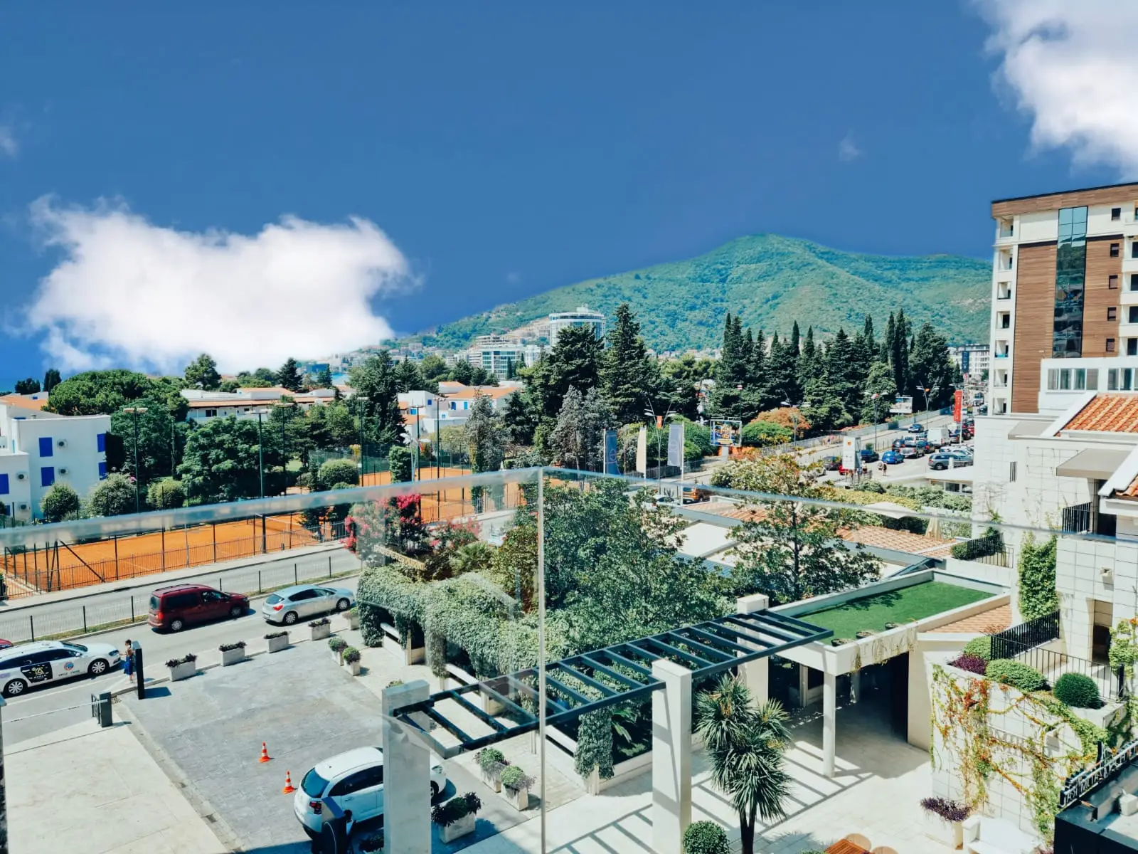 Mountain view over street, tennis court, and apartment buildings