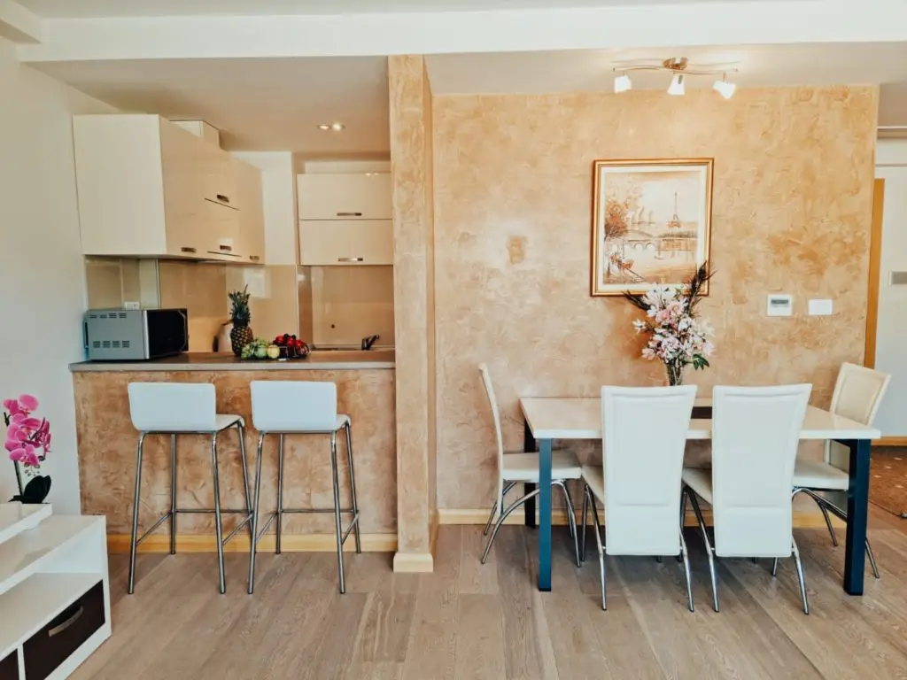 Modern kitchen and dining area with white chairs and bar stools