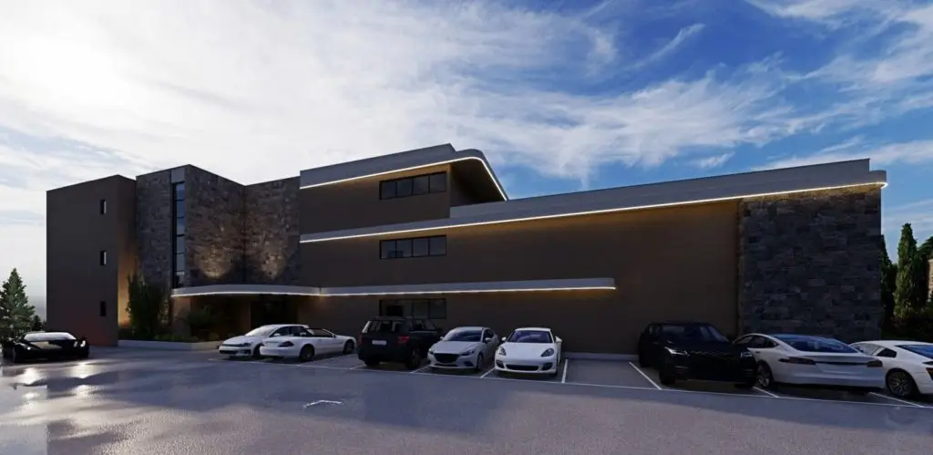 Modern apartment building with parked cars and stone фасade