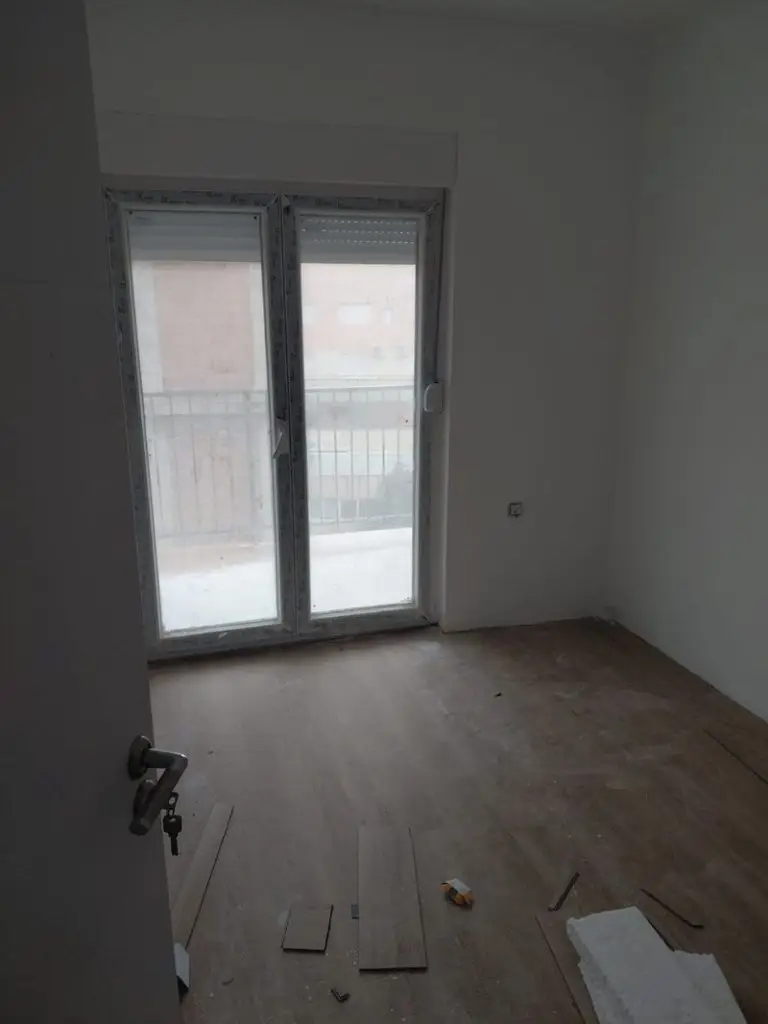 Empty unfinished room with balcony doors and wood flooring material
