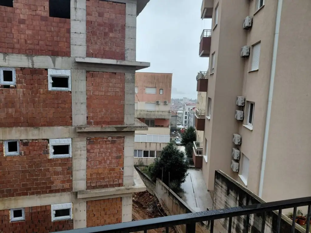 View between apartment buildings with wet walkway below