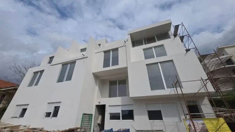White apartment building under construction with scaffolding