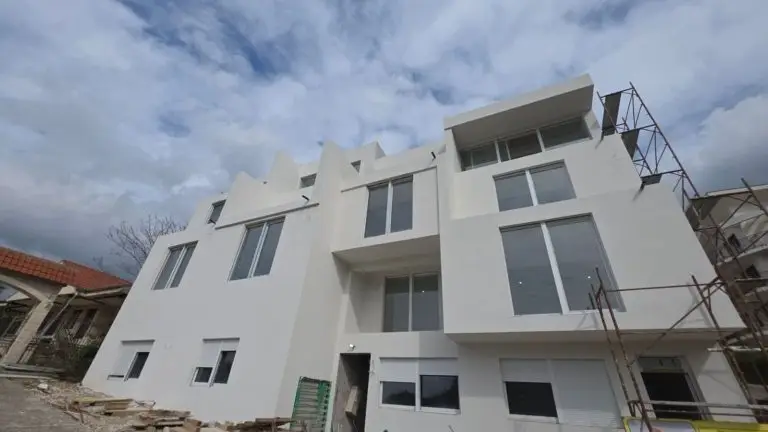 White apartment building under construction with scaffolding