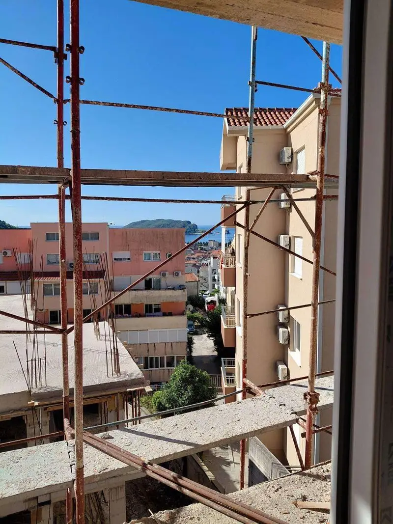 View through scaffolding to buildings and sea in distance